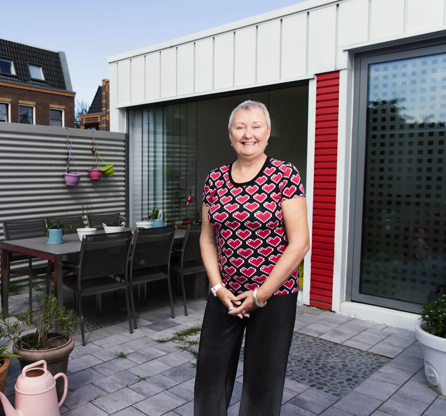Vrouw in achtertuin van haar duurzame woning gebouwd van zeecontainers
