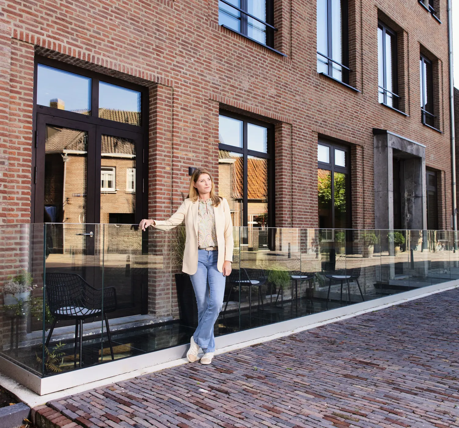Vrouw poseert bij haar nieuwbouwwoning.