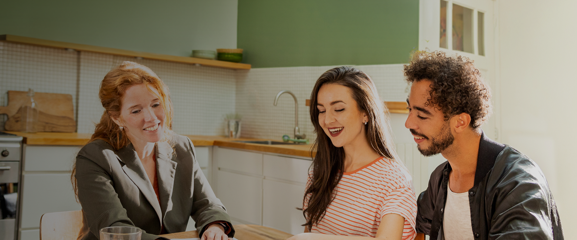 Adviseur in gesprek met haar klanten. Samen bekijken ze wat documenten.