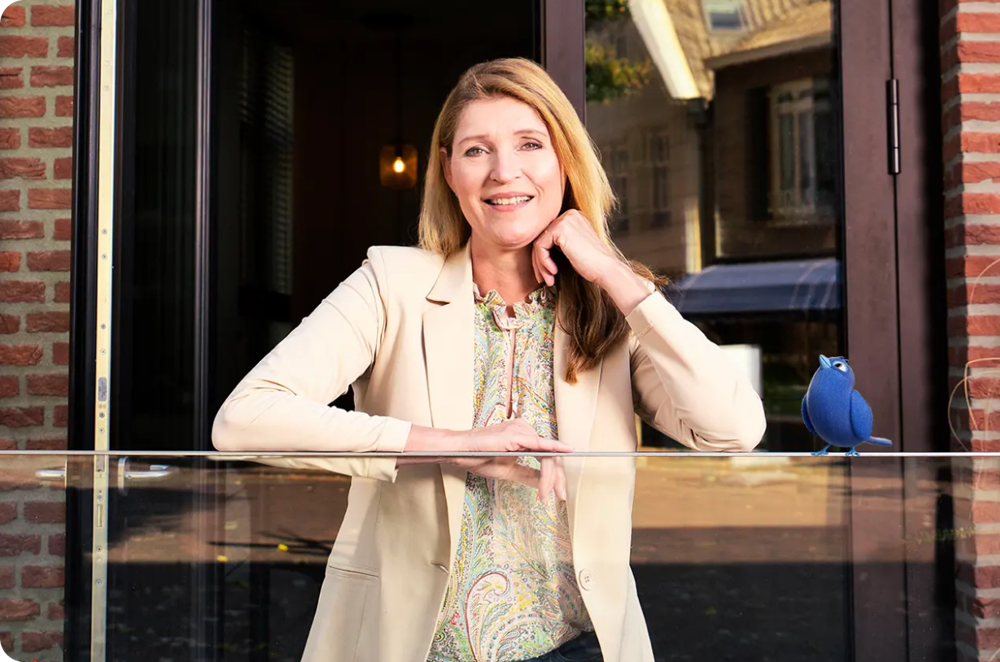 Vrouw staat op het balkon van haar eigen woning.